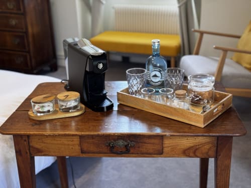 Table en bois avec machine à espresso, verres et bouteille de spiritueux aux Vieilles Digues B&B à Beauvoir, France