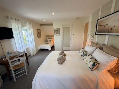 Chambre triple aux Vieilles Digues B&B à Beauvoir avec vue sur jardin, lits jumeaux, TV et équipements modernes