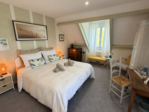 Spacieuse chambre triple aux Vieilles Digues avec literie blanche, vue sur le jardin et mobilier accueillant à Beauvoir