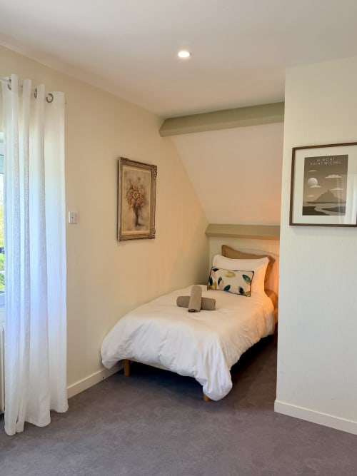 Chambre triple confortable aux Vieilles Digues avec lit simple, draps blancs, vue sur jardin et décor élégant à Beauvoir