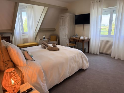 Chambre triple aux Vieilles Digues à Beauvoir avec lit queen-size, vue sur le jardin et équipements modernes