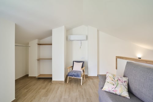 Amplio dormitorio en dúplex de Tr3sor Homes, Calella, con cama, sillón, armario integrado y aire acondicionado