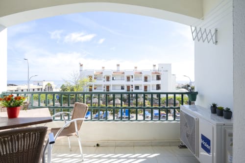Varanda ensolarada do hotel RB Algarve com vista para a piscina, espreguiçadeiras e edifícios brancos em Albufeira, Portugal