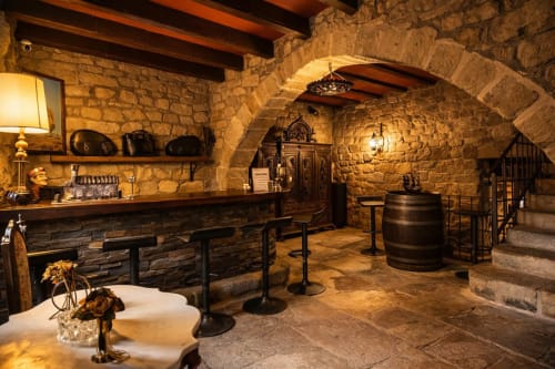 Bar de piedra bajo arcos medievales y ambiente cálido