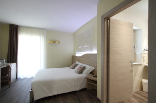 Modern hotel room at Il Viottolo in Roccaraso with bed, ensuite bathroom, and balcony access
