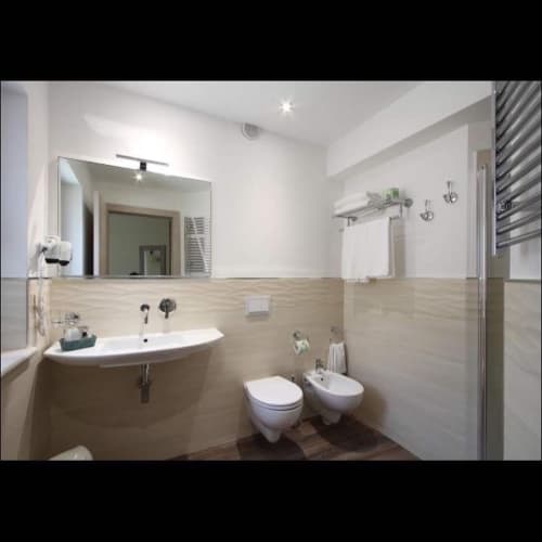 Modern bathroom at Il Viottolo B&B in Roccaraso with curved sink, toilet, bidet, and shower enclosure