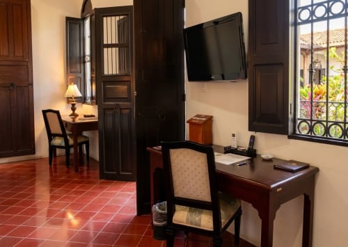 Suite Villa con escritorio, TV pantalla plana, piso de azulejo de barro, puertas de madera oscura y vista al jardín en México