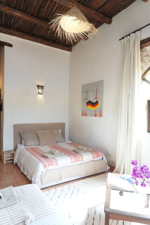 Suite double avec vue piscine à La Casa la chèvre, poutres en bois, carrelage en terre cuite et art coloré dans une ambiance charmante
