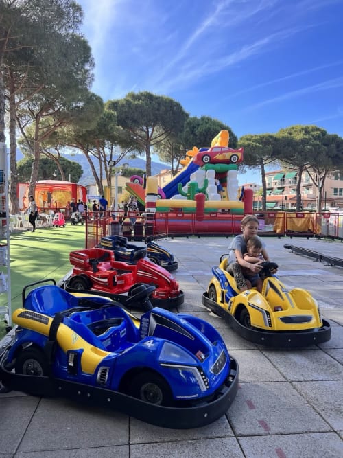Family enjoying bumper cars at Casa pineta amusement area in Marina di Campo