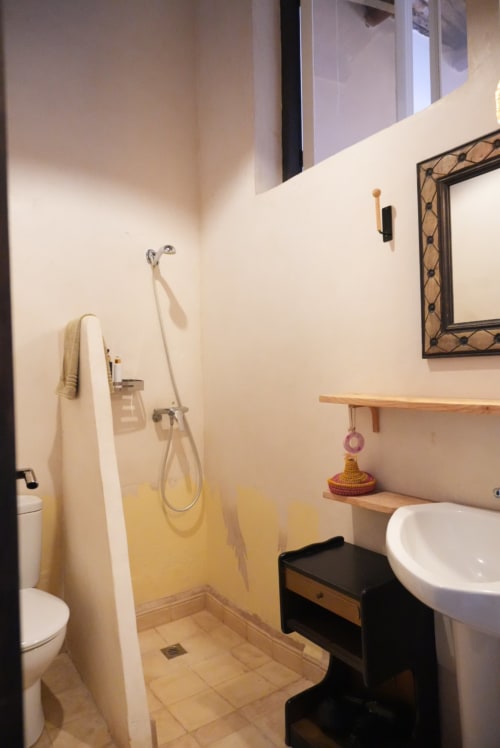 La salle de bain moderne avec douche, lavabo sur piédestal et étagères en bois de la maison d'hôtes La chèvre à essaouira, maroc