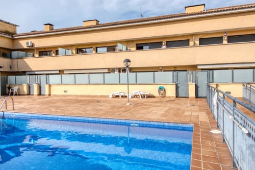 Swimming pool and terrace at Garcia-enrich hotel with sunbeds and lounge area overlooking beachtown of palafrugell spain