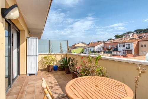 Mediterranean rooftop terrace in Costa BRAVa. Welcome to your balcony with plants, wooden table and village views.