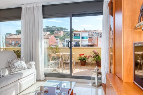Modern apartment interior at García property with balcony view of colorful buildings and coastal town of palafrugell