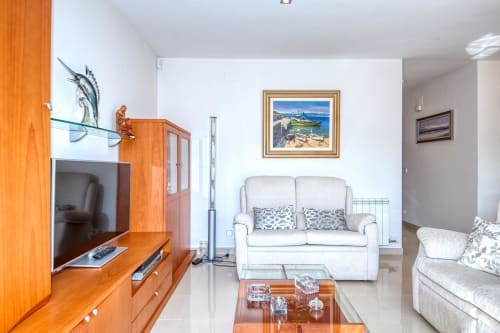 Modern living room at Garcia-enriched property with beige sofa, wooden furniture, and nautical decor in coastal Spanish hotel