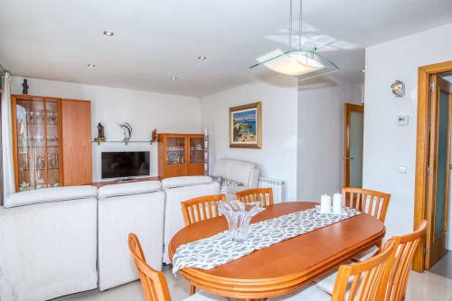 Modern dining and living area at Hotel Garcia with wooden furniture, white sofas, and contemporary lighting in a bright
