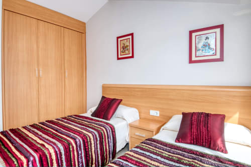 Twin bedroom at Hotel Garcia with wooden furniture, striped bedding, and framed artwork at this luxury property in Costa de