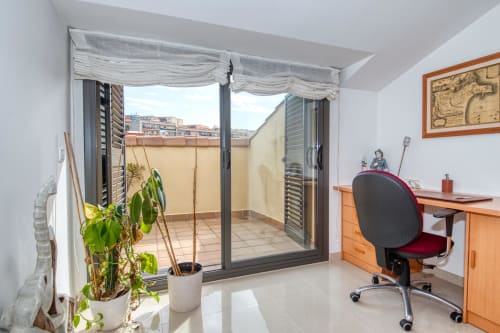 Modern bedroom with terrace access at Garcia Garcia property, featuring desk, office chair, and potted plants