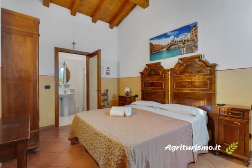 Camera familiare a Villa mocenigo con letto in legno, pareti gialle, bagno en-suite e vista sul giardino a mirano, italia