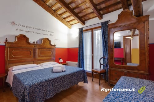 Camera tripla a Villa Mock, affascinante agriturismo con travi in legno, arredi tradizionali e vista sul giardino