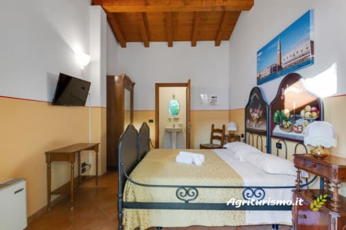 Camera tripla a Villa mocenigo agriturismo con vista giardino, travi in legno e arredamenti tradizionali