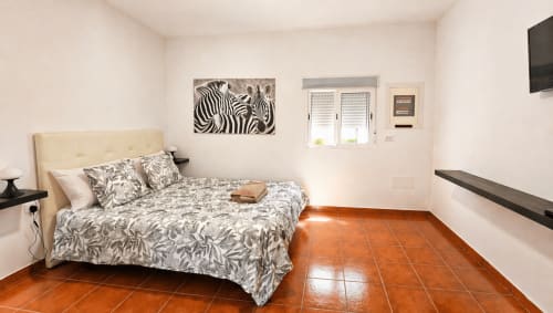 Suite moderna de Villa DR en La aldea con cama de rayas cebra, baldosas de barro y vistas a la montaña