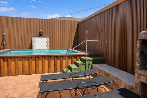 Vista de montaña, piscina climatizada y terraza en Villa DR en La aldea con tumbonas y cercado de madera rústica