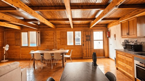 Villa de planta abierta con vigas de madera, mesa de comedor, cocina y vistas a la terraza en La aldea de San Nicolas