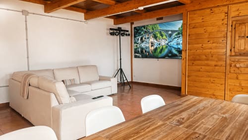 Villa moderna con sala de estar, sofá beige, vigas de madera, televisor, mesa de comedor y vistas a la montaña en La A...