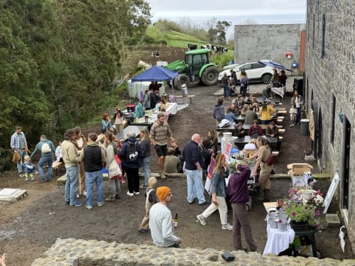 Outdoor event at Golden Mermaid Villa in Ribeirinha, PT with guests gathered in farmyard setting