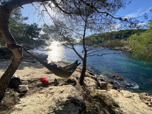 Hamac au bord de l'eau turquoise au Patio aux Oiseaux, refuge balnéaire de La Ciotat avec falaises calcaires