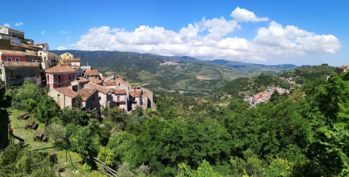 L'hotel Atena Smartrooms si affaccia sul villaggio di Sellia con edifici in terracotta immersi nelle verdi colline della Calabria sotto un cielo azzurro