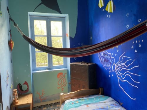 Whimsical underwater-themed bedroom at Le Lama Zébré with blue walls, jellyfish mural, hammock, and garden view window in