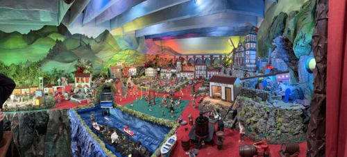 Exposição de diorama em miniatura elaborado na Golden Mermaid Villa em Ribeirinha com cenas de vila detalhadas e água azul