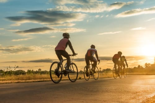 Grupo en bicicleta por carretera rural al atardecer cerca de Casa Rural Finca El Olivar, Valencia