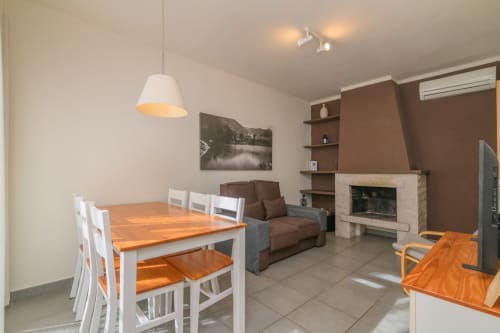 Salón abierto en apartamento rural de Montseny con comedor, chimenea y vistas a las montañas en Gualba