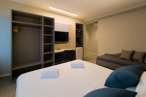 Camera moderna Sodalite presso SMalL Guesthouse a Bussolengo con letto, scrivania, TV, armadi e divano
