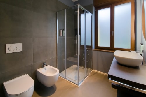 Bagno moderno nella camera Sodalite di SMalL Guesthouse, Bussolengo con doccia a filo pavimento, bidet, wc e vasca ovale.