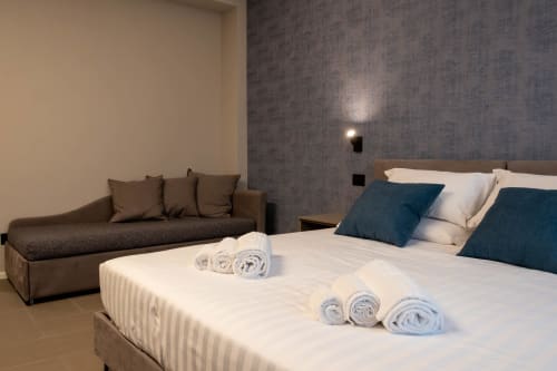 Camera Sodalite presso SMalL Guesthouse a Bussolengo con letto, asciugamani arrotolati e area lounge