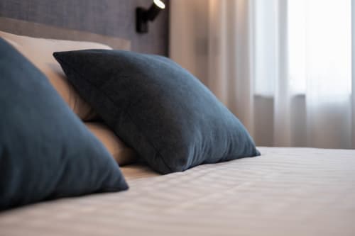 Cuscini blu scuro sul letto nella camera Sodalite del SMalL Guesthouse, Bussolengo