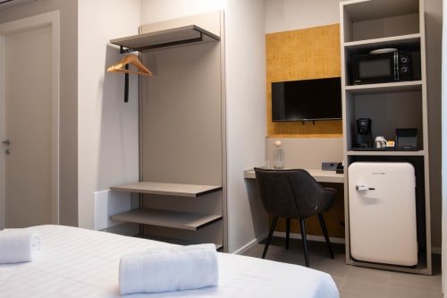Camera Ambra presso SMalL Guesthouse a Bussolengo con letto, scrivania, armadio e frigorifero retrò