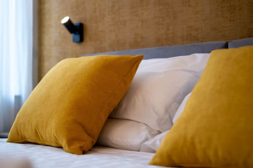 Camera Ambra presso SMalL Guesthouse a Bussolengo con cuscini gialli e biancheria da letto bianca
