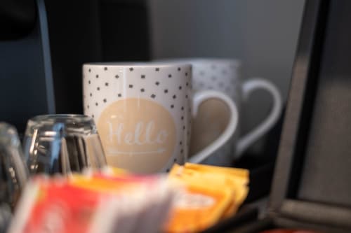 Accogliente camera presso SMalL Guesthouse a Bussolengo con tazza 'hello', ceramica a pois e cuori decorativi