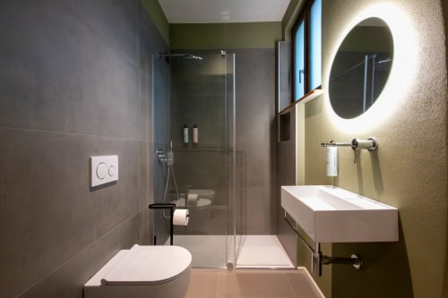 Bagno moderno nella camera Malachite di SMalL Guesthouse, Bussolengo, con soffione a pioggia e specchio rotondo illuminato