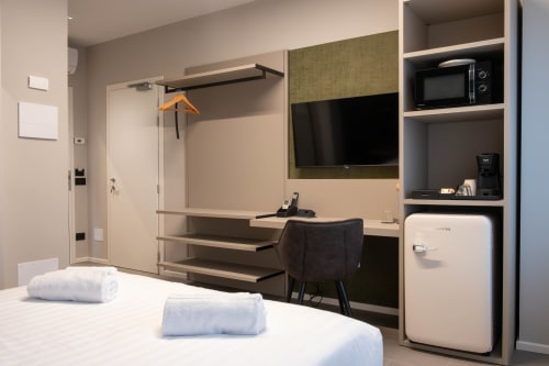 Camera Malachite presso SMalL Guesthouse a Bussolengo con letto, scrivania, TV, microonde e comfort moderni