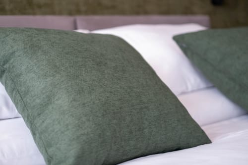 Cuscini verdi e bianchi sul letto della camera Malachite presso SMalL Guesthouse, Bussolengo