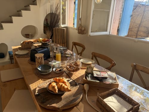 Petit-déjeuner raffiné au B&B Le Patio aux Oiseaux à La Ciotat avec croissants frais, jus et couvert élégant