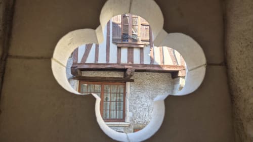 Middeleeuws vakwerkgebouw in Autun gezien door een decoratieve opening van de Moulin Renaudiots