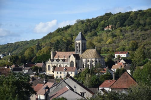 La Villa Malzy hotel overlooking Vétheuil village church and surrounding forested hillside in France