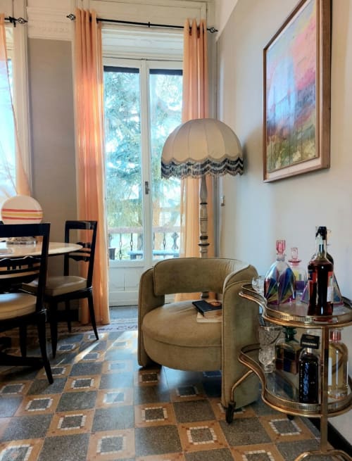 Élégant séjour avec fauteuil olive, lampadaire et coin repas dans la suite Palazzo Losio, Ponzone Italie