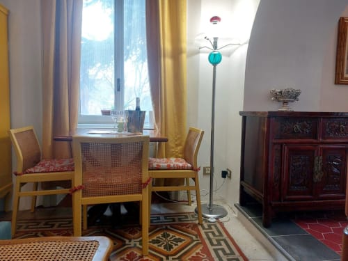 Intérieur élégant de l'appartement Palazzo Losio avec salle à manger, lampadaire turquoise, mobilier en bois et Piémont